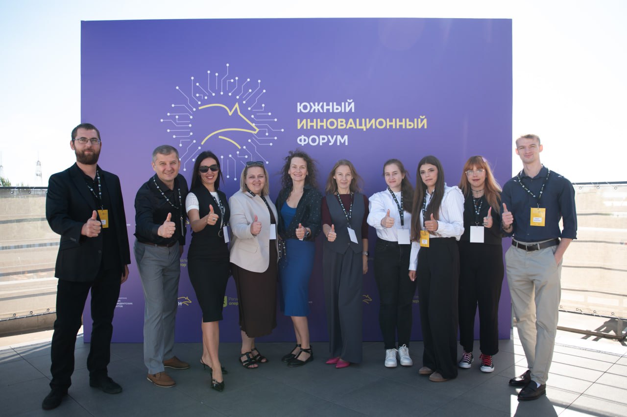 фото участников на фоне баннера форума